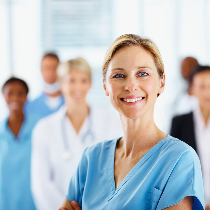 Keyvisual_SICHER_iStock Leitende Ärztin mit Team im Hintergrund