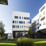 Außenaufnahme des Lehr- und Forschungsgebäudes Haus C am PMU Campus im Sommer