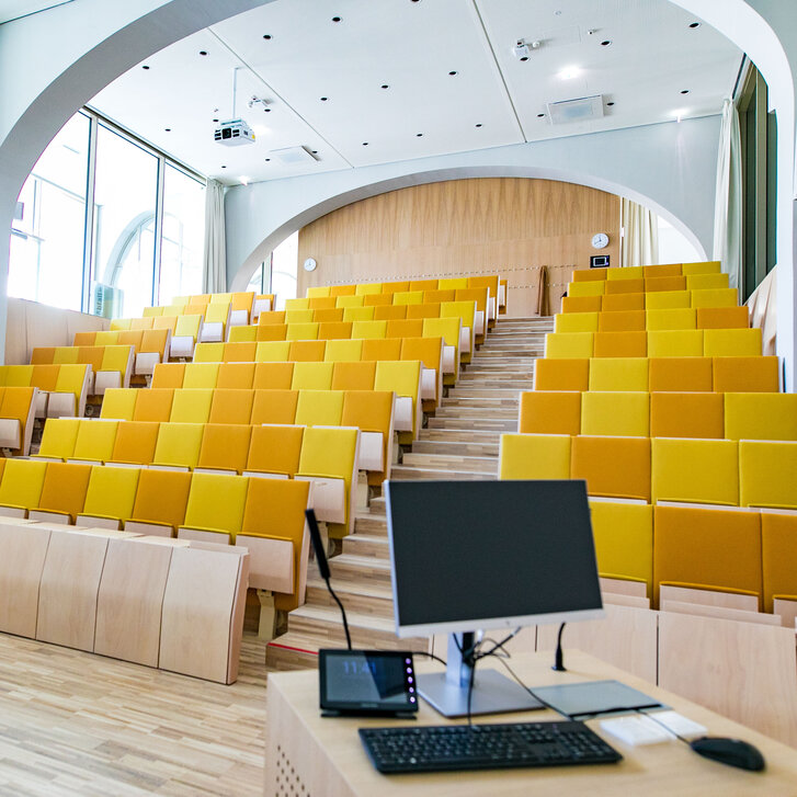 Moderner Hörsaal mit bunten Sitzreihen