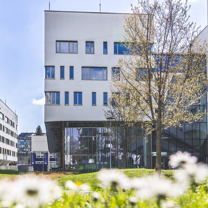 Außenaufnahme des Lehr- und Forschungsgebäudes Haus C am PMU Campus im Frühling