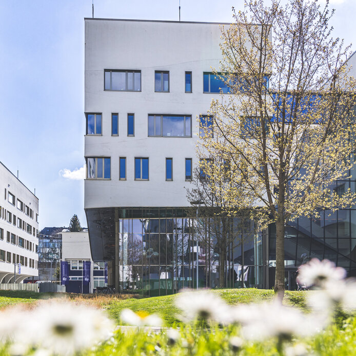 Außenaufnahme des Lehr- und Forschungsgebäudes Haus C am PMU Campus im Frühling