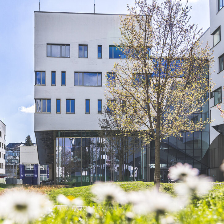 Außenaufnahme des Lehr- und Forschungsgebäudes Haus C am PMU Campus im Frühling