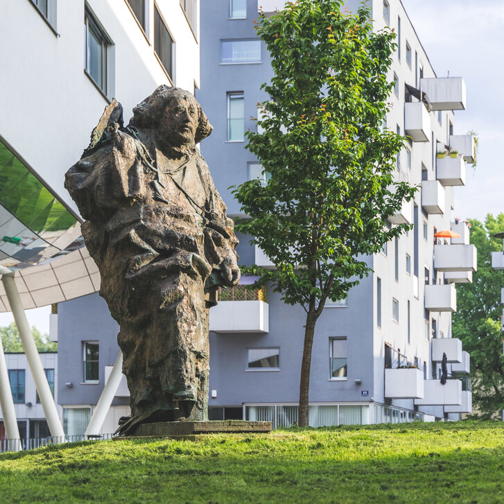 Paracelsus Statue im Grünen im Frühling am PMU Campus in Salzburg
