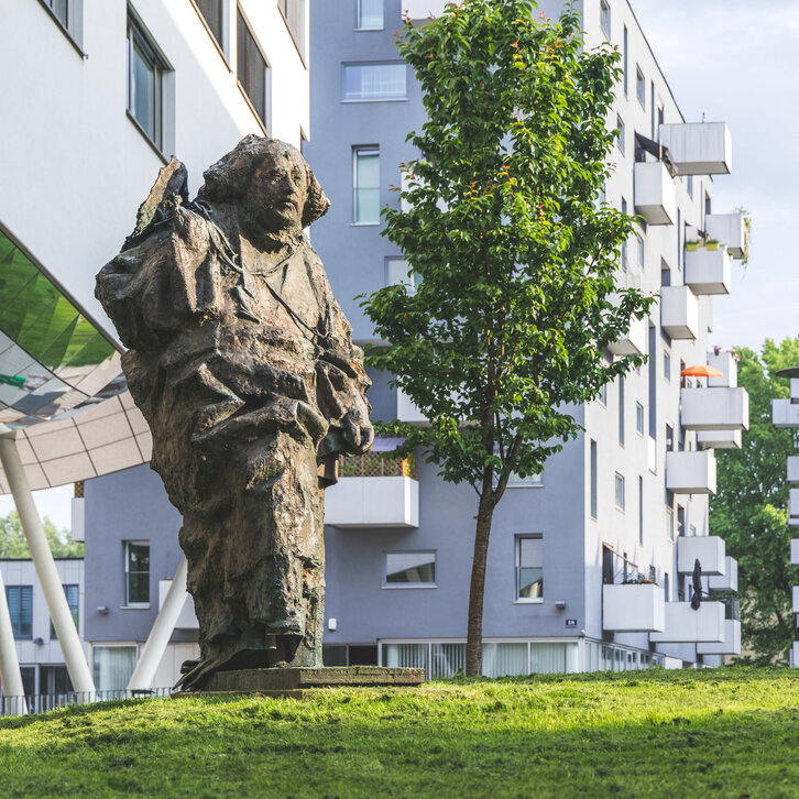 Paracelsus Statue im Grünen im Frühling am PMU Campus in Salzburg