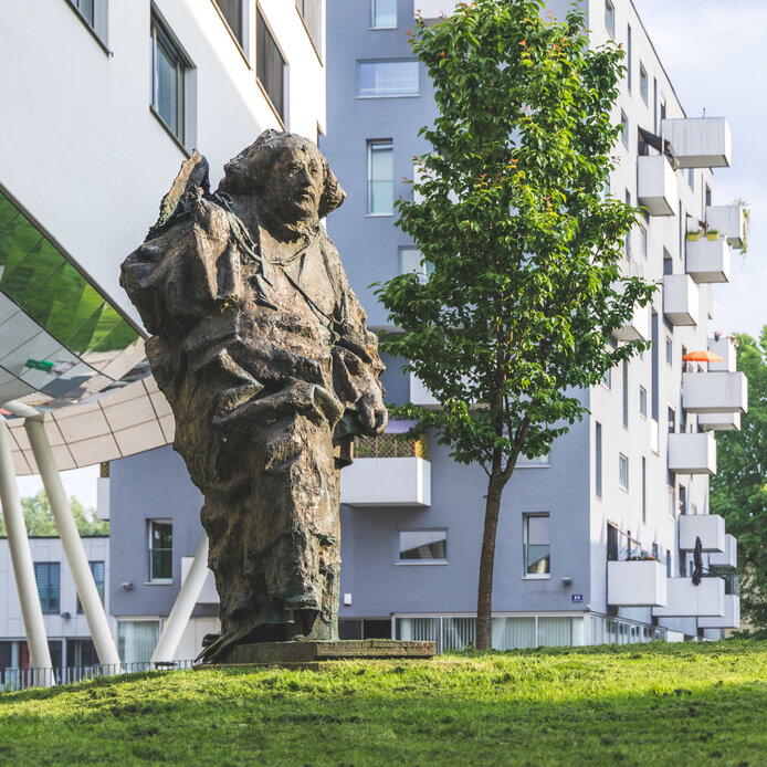 Paracelsus Statue im Grünen im Frühling am PMU Campus in Salzburg