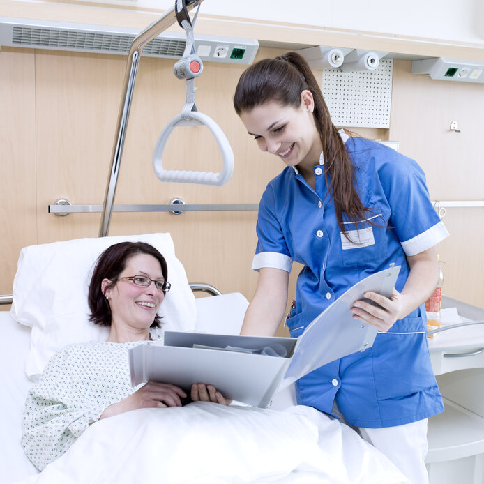 Pflegerin behandelt Patientin am Krankenbett